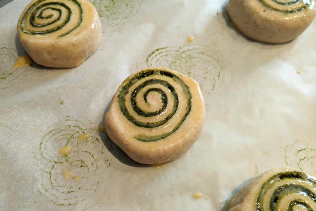 Rollos de té Matcha pincelados con huevo antes de entrar al horno.